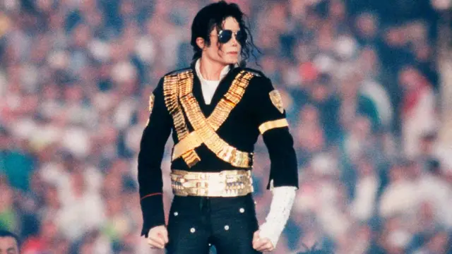 Siyah ve altın renkli bir kostüm giyen şarkıcı Michael Jackson, 1993 yılında California’nın Pasadena kentinde düzenlenen Super Bowl'da devre arası şovunda sahne alırken görülüyor.